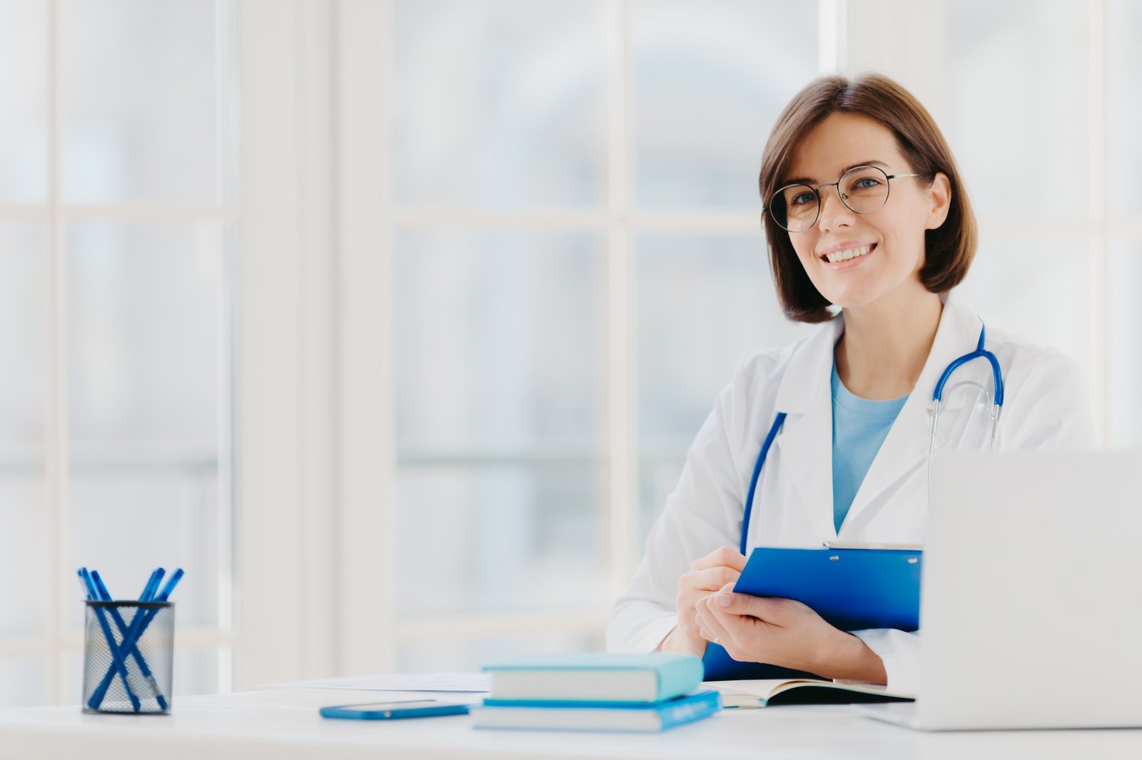Female doctor writes prescription on special form, works in private clinic