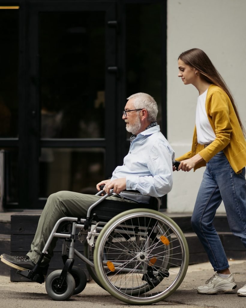 Daughter and disabled father go for a walk