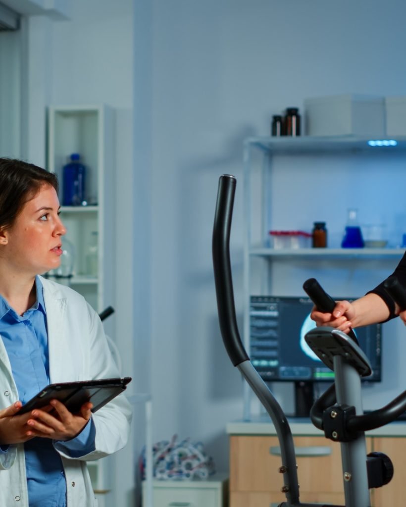 Woman with mask running on cross trainer testing heart rate